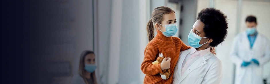 2020s - Young girl, with a teddybear, in the arms of a doctor